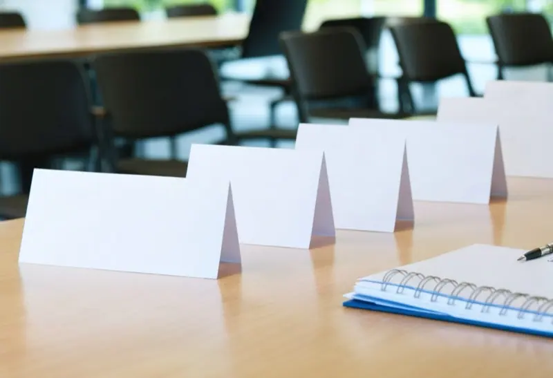 Row of blank white name tents on a conference room table